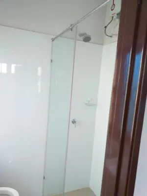 a glass shower in a bathroom with a toilet at Hotel Peking in Taiping