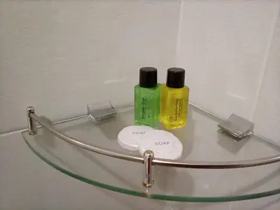 two bottles ofodorizers sitting on a glass shelf in a bathroom at Hotel Pangkor SJ in Pangkor