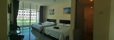 a hotel room with two beds and a window at Hotel Pangkor SJ in Pangkor