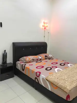 a bedroom with a bed with a colorful comforter at Family Homestay in Taiping