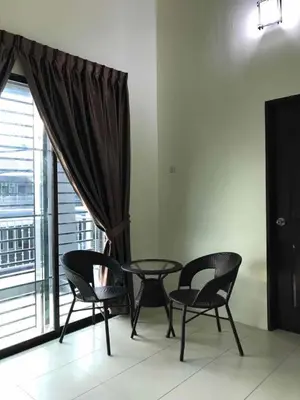 two chairs and a table in a room with a window at Family Homestay in Taiping