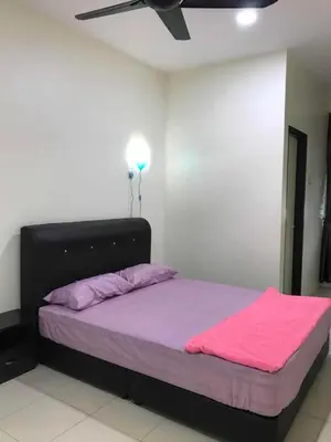 a bedroom with a bed with a pink blanket on it at Family Homestay in Taiping