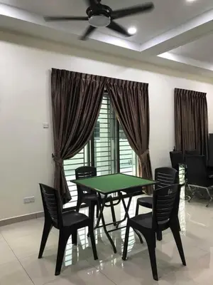 a dining room with a green table and chairs at Family Homestay in Taiping