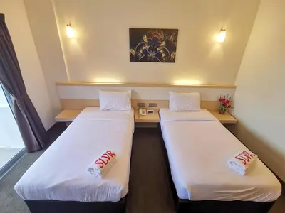 two beds in a room with white sheets at SERDANG LAKE VIEW RESORT in Sungai Kechil