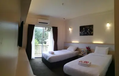 a hotel room with two beds and a window at SERDANG LAKE VIEW RESORT in Sungai Kechil