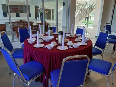 a table with a red table cloth and blue chairs at SERDANG LAKE VIEW RESORT in Sungai Kechil