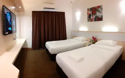 a hotel room with two beds and a flat screen tv at SERDANG LAKE VIEW RESORT in Sungai Kechil