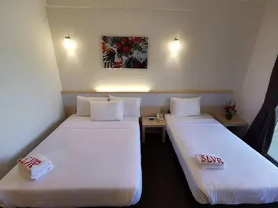 two beds in a hotel room with sidx sidx sidx sidx at SERDANG LAKE VIEW RESORT in Sungai Kechil