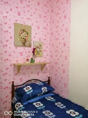 a bedroom with a bed and a pink wall with hearts at Alyaleesya Muslim Homestay in Tanah Rata