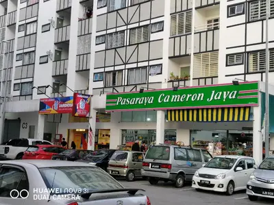 a parking lot with cars parked in front of a building at Alyaleesya Muslim Homestay in Tanah Rata