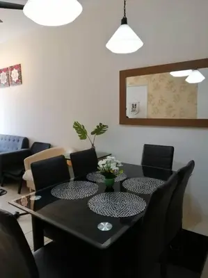 a dining room with a black table and chairs at Alyaleesya Muslim Homestay in Tanah Rata
