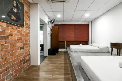 a bedroom with two beds and a brick wall at UrbanStay Industrial in Ipoh