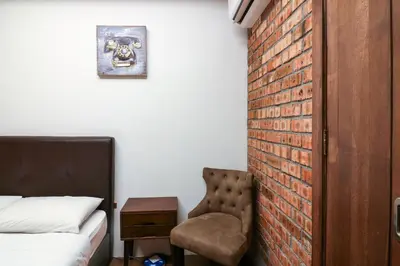 a bedroom with a brick wall and a chair at UrbanStay Industrial in Ipoh