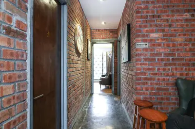 an alley with a brick wall and some chairs at UrbanStay Industrial in Ipoh