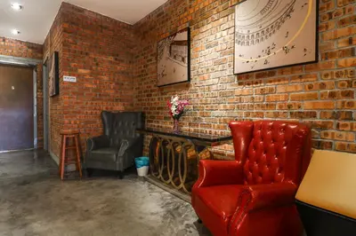 a room with two chairs and a brick wall at UrbanStay Industrial in Ipoh