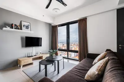 a living room with a couch and a large window at Tropicana 218 Macalister by Simply Penang in George Town