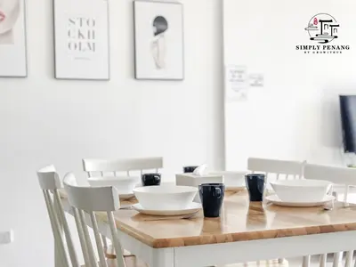 a dining room table with white dishes on it at Tropicana 218 Macalister by Simply Penang in George Town