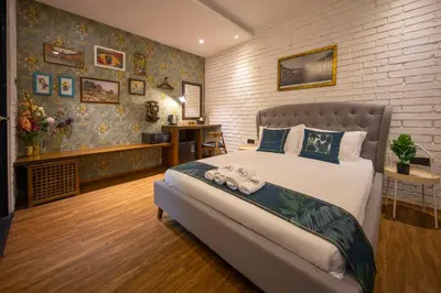 a bedroom with a large bed and a brick wall at Carnarvon Suites in George Town