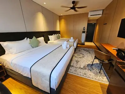 a hotel room with two beds and a fan at Carnarvon Suites in George Town