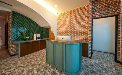 an office with a brick wall and a desk with a laptop at Carnarvon Suites in George Town