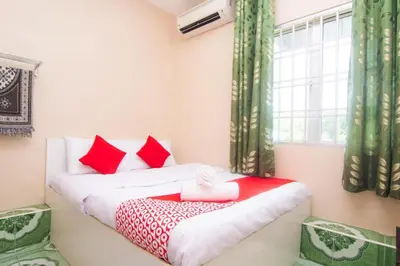 a bedroom with two beds with red and white pillows at Hotel O Hajah Rohayah in Tanjung Malim