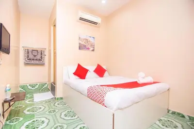 a small bedroom with a bed with red pillows at Hotel O Hajah Rohayah in Tanjung Malim