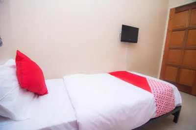 a bedroom with a bed with red pillows on it at Hotel O Hajah Rohayah in Tanjung Malim