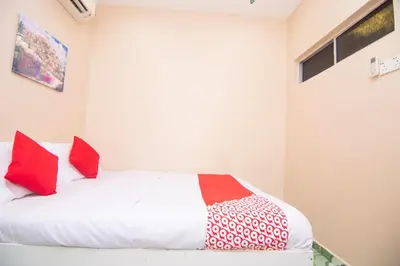 a bedroom with a bed with red and white pillows at Hotel O Hajah Rohayah in Tanjung Malim