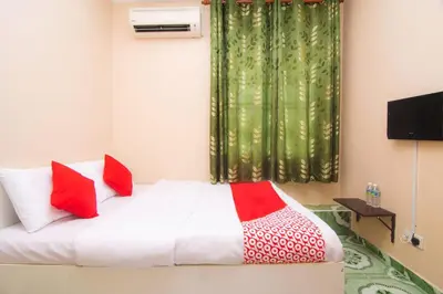 a bedroom with a bed with red and white pillows at Hotel O Hajah Rohayah in Tanjung Malim