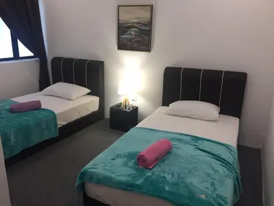 a room with two beds and a lamp in it at COMFORTABLE STAY in Ayer Itam