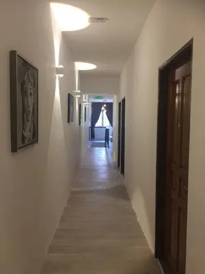 a hallway with white walls and a wooden floor at COMFORTABLE STAY in Ayer Itam