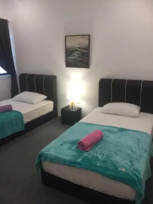a room with two beds and a red pillow on it at COMFORTABLE STAY in Ayer Itam