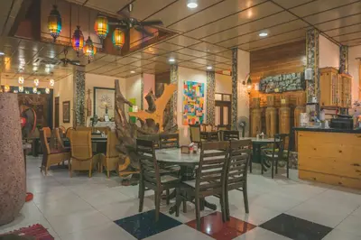 a dining room with a table and chairs at Lost Paradise Resort in Batu Ferringhi