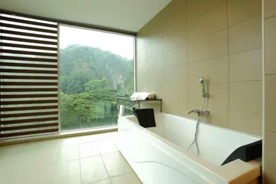 a bathroom with a tub with a phone on the wall at Symphony Suites Hotel in Ipoh