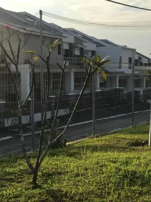 a small tree in front of a fence at Ipoh Water Front City Homestay in Ipoh