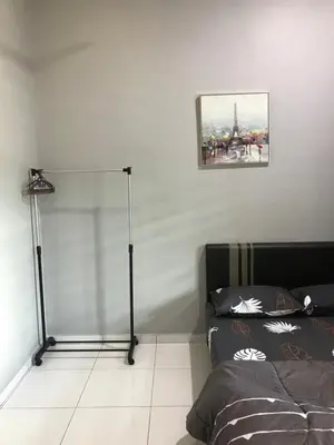 a bedroom with a bed and a floor lamp at Ipoh Water Front City Homestay in Ipoh