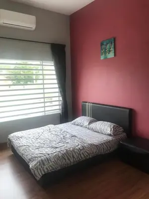a bedroom with a bed and a red wall at Ipoh Water Front City Homestay in Ipoh