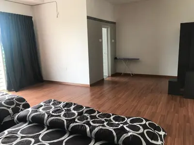 an empty room with a bed and a wooden floor at Ipoh Water Front City Homestay in Ipoh