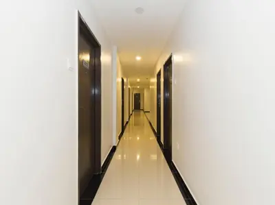 a corridor of a building with white walls and a long hallway at B&L HOTEl in Sungkai