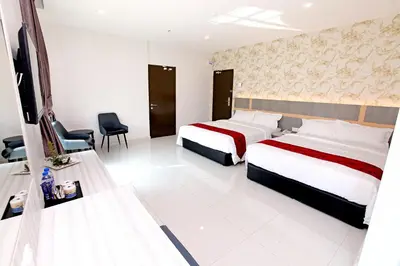 a hotel room with two beds and a chair at B&L HOTEl in Sungkai