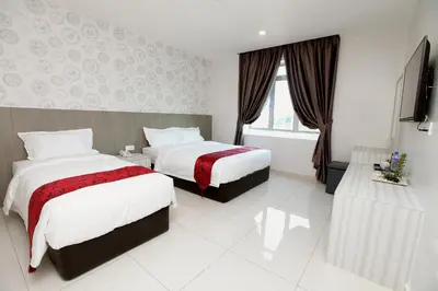 a hotel room with two beds and a television at B&L HOTEl in Sungkai