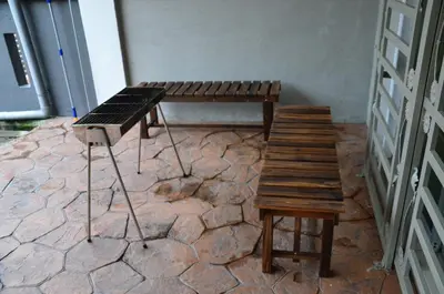 a bench and a table and a stool in a room at The Woodz Homestay - 2 Storey Landed House in Cameron Highlands
