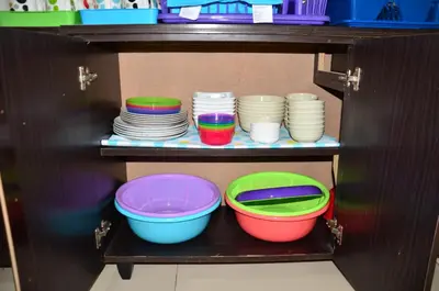 a shelf with plates and bowls in a cabinet at The Woodz Homestay - 2 Storey Landed House in Cameron Highlands