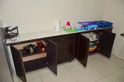 a kitchen counter with wooden cabinets and a phone at The Woodz Homestay - 2 Storey Landed House in Cameron Highlands