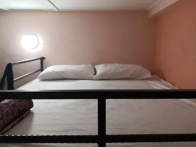 a bed with white sheets and pillows in a room at Hua Tang Homestay in Ipoh