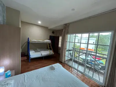 a bedroom with a bed and a window with a balcony at EagleNest at Iris House Resort in Tanah Rata