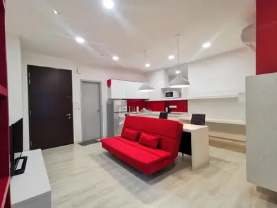a living room with a red couch and a kitchen at Strait Garden Studio X Ace Pro @ George Town in George Town