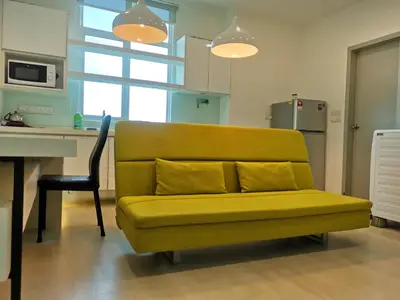 a yellow couch in a kitchen with a desk at Strait Garden Studio X Ace Pro @ George Town in George Town