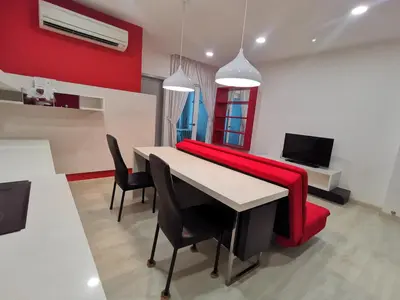 a dining room with a red couch and a table at Strait Garden Studio X Ace Pro @ George Town in George Town