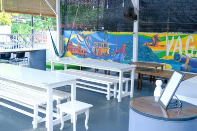 a group of tables and benches in front of a mural at Vagary Pangkor in Pangkor
